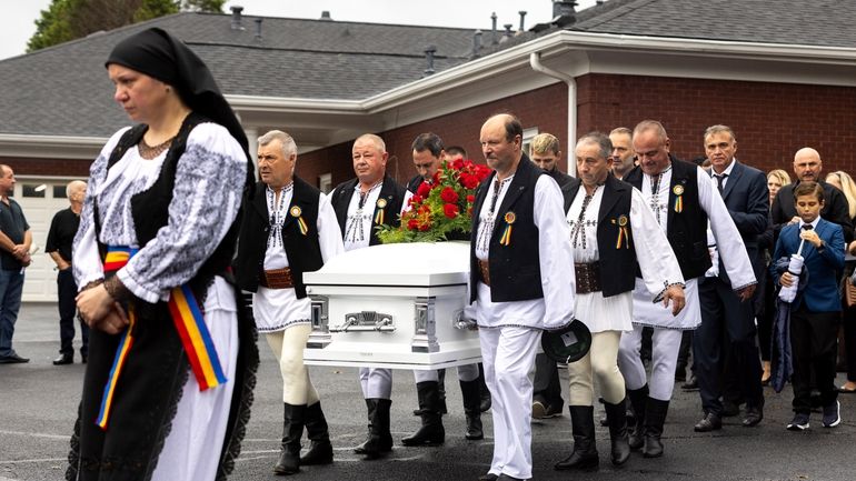 Mourners carry the casket of Ana Cristina Irimie, a math...