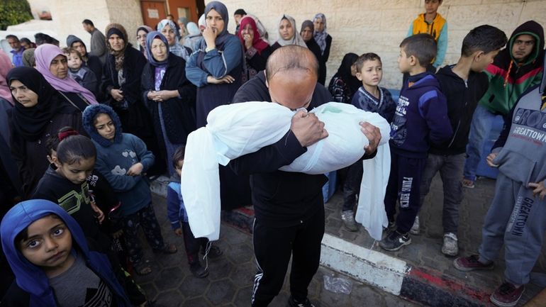 A Palestinian morns a relative killed in the Israeli bombing...