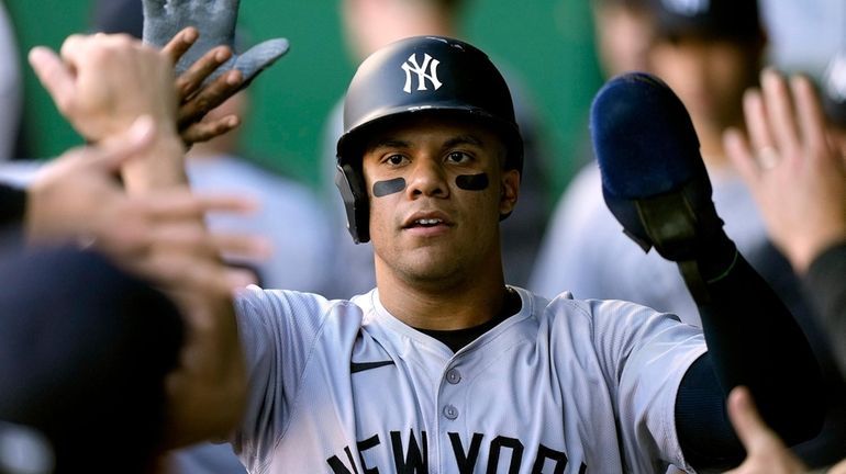 The Yankees' Juan Soto celebrates in the dugout after scoring...