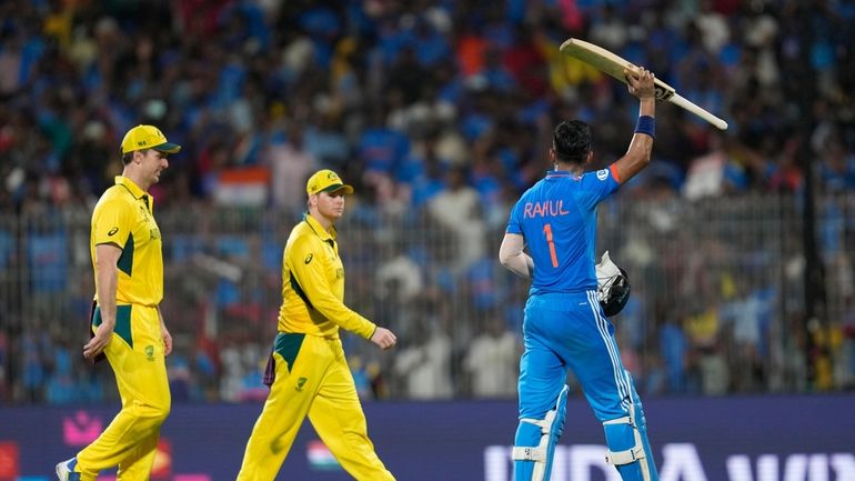 India's KL Rahul, right, raises his bat as he acknowledges...