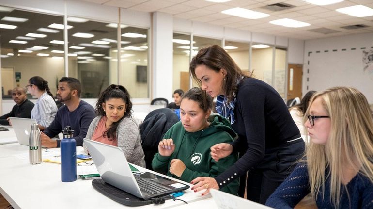 LIU Post assistant dean Graziela Fusaro, second from right, guides...