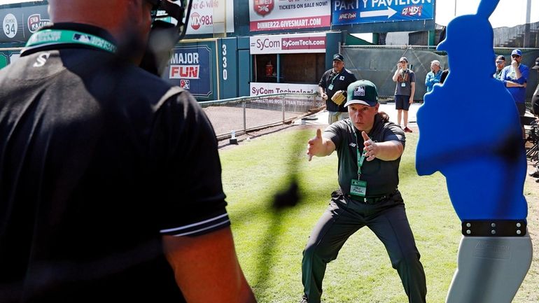 Umpire Jen Pawol, front right, works with students during MLB...