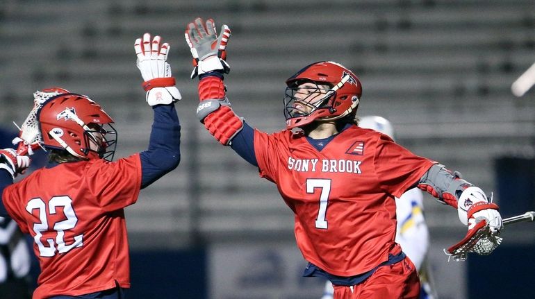 Stony Brook's Tom Haun congratulates teammate Jack Walsh for his...