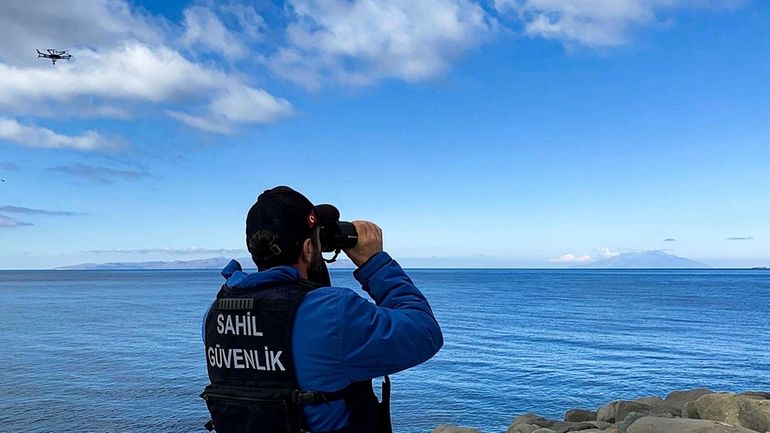 A member of Turkish Coastal Security uses binoculars on the...