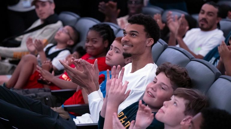 San Antonio Spurs' Victor Wembanyama, center, watches videos with local...