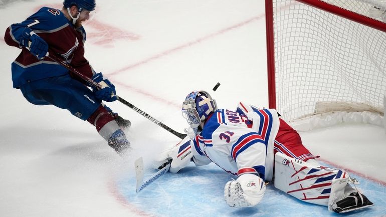 Rangers goaltender Igor Shesterkin, right, deflects a shot by Colorado...