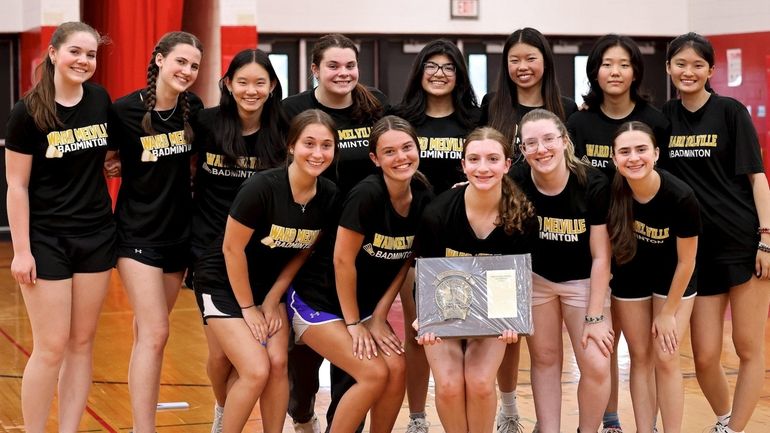 Ward Melville's girls badminton team poses with the championship plaque after...