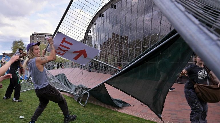 Demonstrators tear down barricades that had been erected outside a...