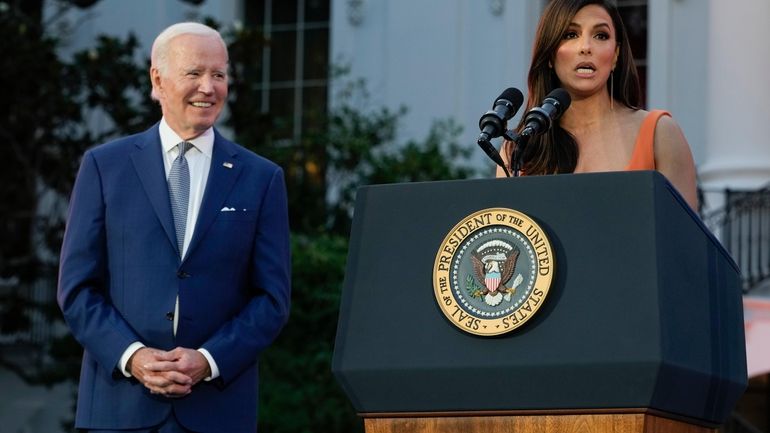 President Joe Biden listens as Eva Longoria speaks before a...