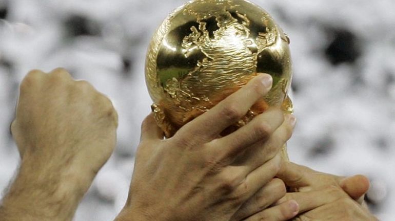 Italy soccer players grab hold of the World Cup trophy...