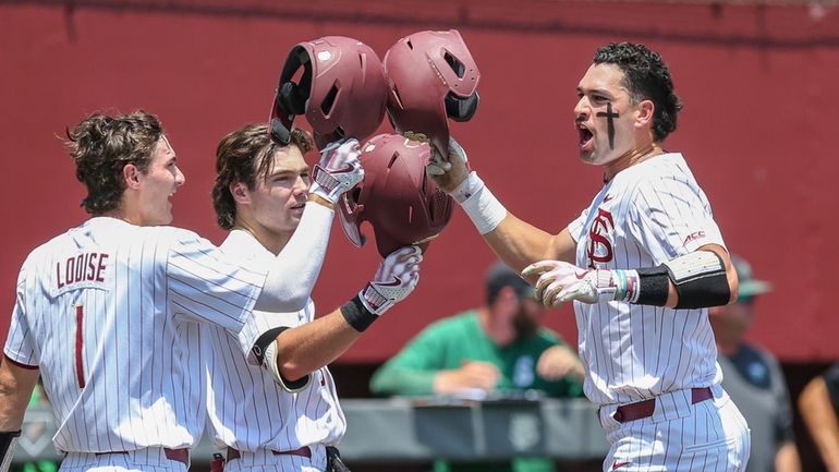 Florida State's Daniel Cantu, right, celebrates his solo home run...