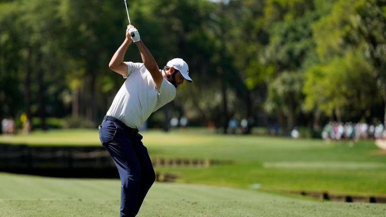 Scottie Scheffler hits his tee shot on the fourth hole...