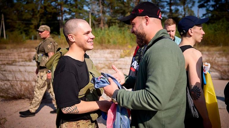 A Ukrainian serviceman, left, is greeted after being released in...