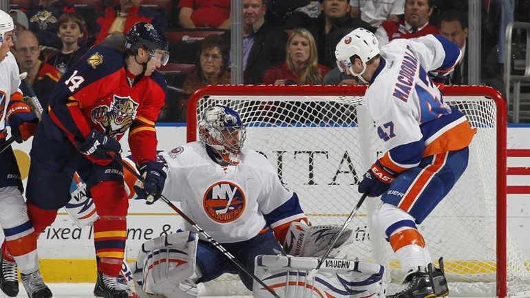 Andrew MacDonald #47 helps defend the net as goaltender Evgeni...