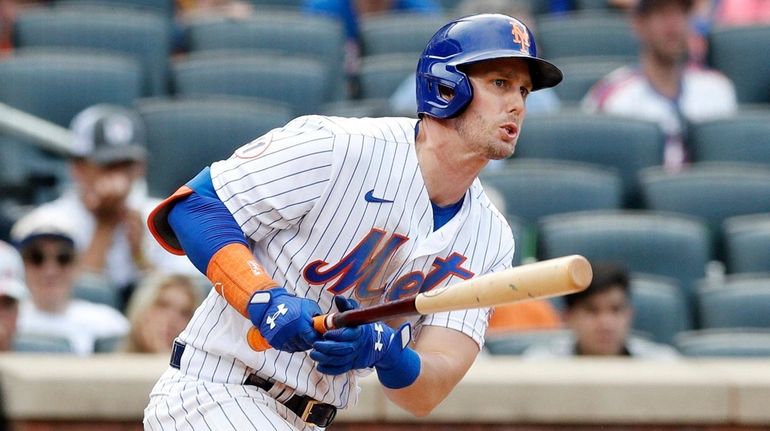 Jeff McNeil of the Mets follows through on an eighth-inning base hit...