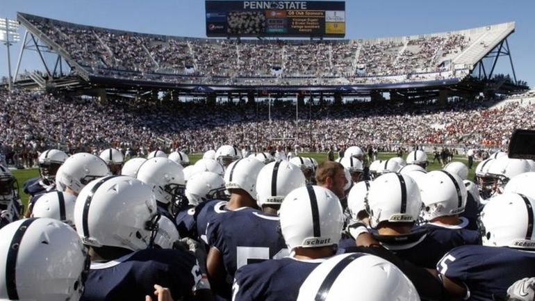 The Penn State football team gathers on the field before...