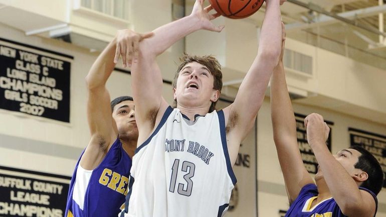 Stony Brook's Bryce Jackson shoots past Greenport's Alex Perez. (Jan....