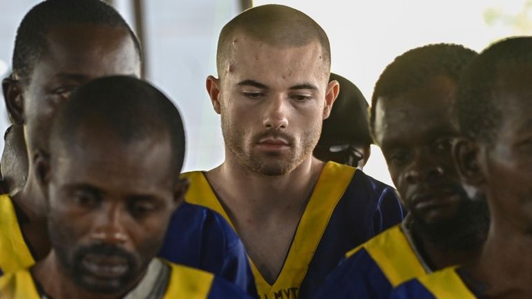 American Tyler Thompson Jr, center, sits in court in Kinshasa,...