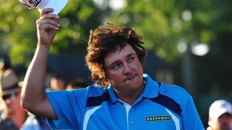 Jason Dufner celebrates on the 18th green after his two-stroke...