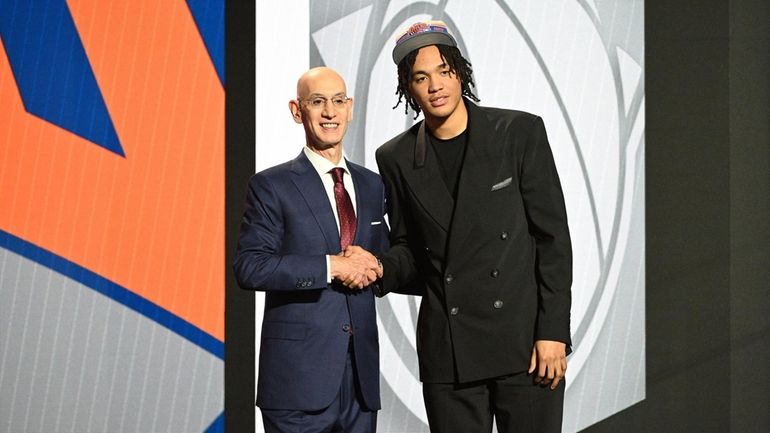 NBA Commissioner Adam Silver congratulates Pacome Dadiet after being selected...