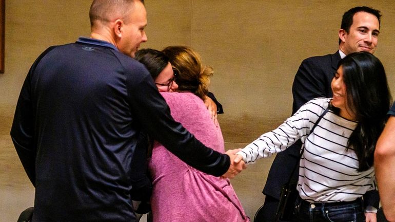 A family member embraces Cemal “John” Dagdeviren's wife, Ulkiye, in...