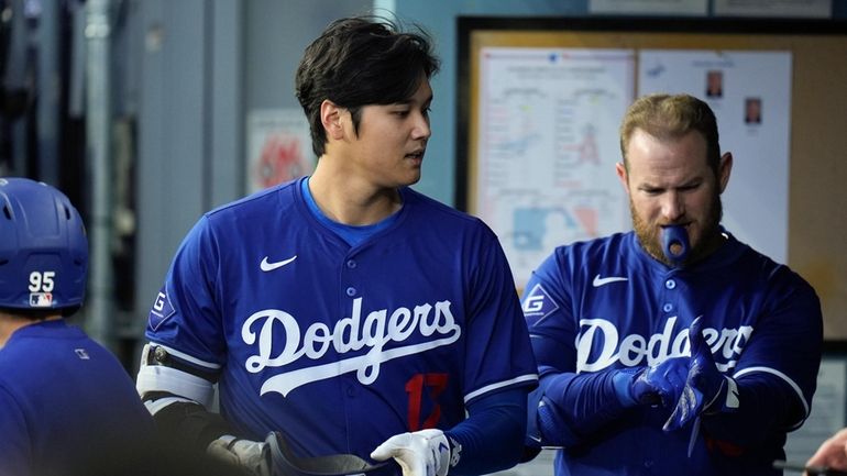 Los Angeles Dodgers' Shohei Ohtani walks into the dugout after...