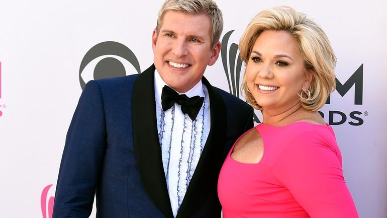 Julie Chrisley, right, and her husband Todd Chrisley pose for...