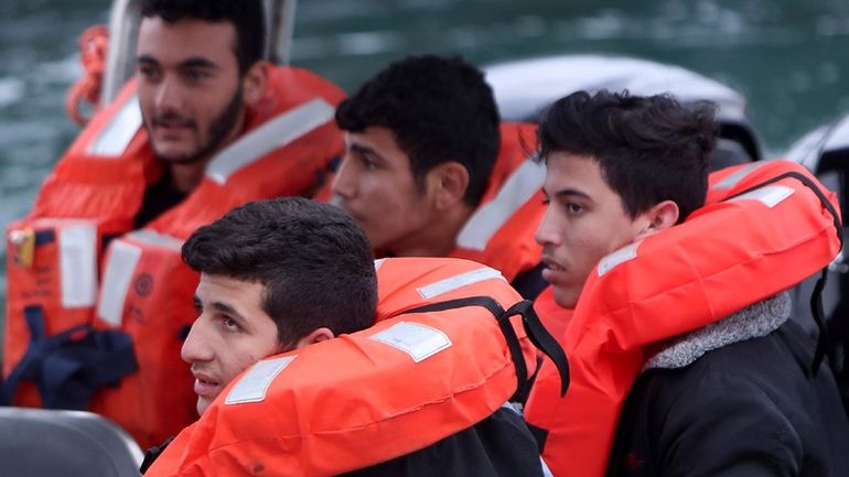 Migrants aboard a Cyprus marine police boat as they are...