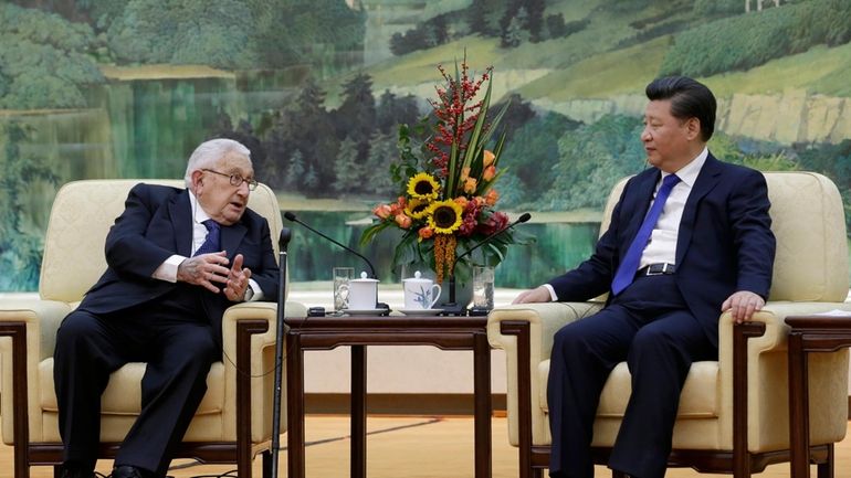 China's President Xi Jinping, right, listens to former U.S. Secretary...