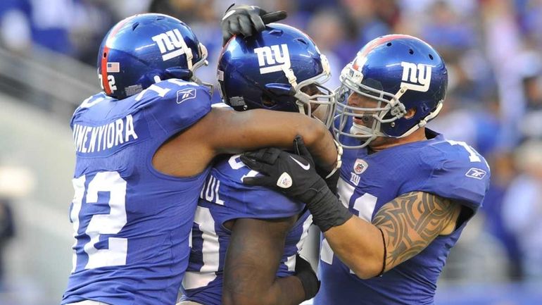 Osi Umenyiora and Dave Tollefson converge on Jason Pierre-Paul after...