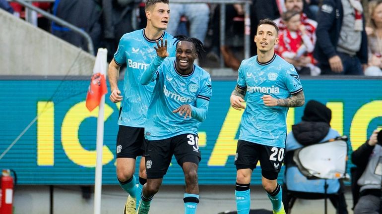 Leverkusen's Jeremie Frimpong, center, celebrates after scoring the opening goal...