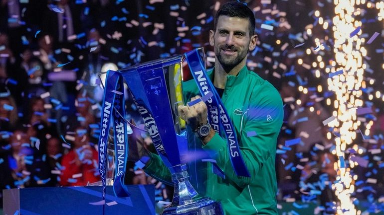 Serbia's Novak Djokovic celebrates with the trophy after winning the...