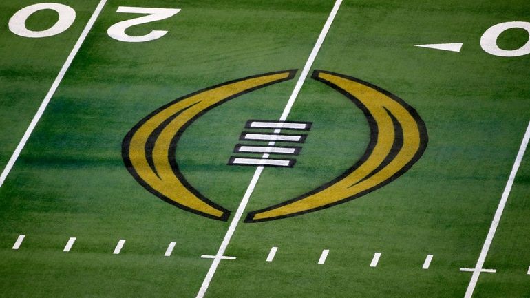 FILE - The College Football Playoff logo is shown on...