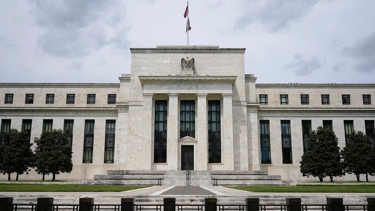 An American flag flies over the Federal Reserve building on...