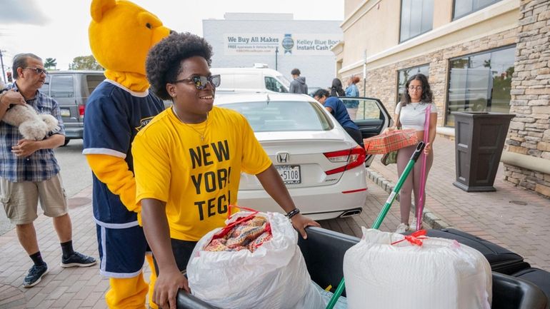 Atreyi Bhatt, 20, right, is helped with her move-in at...