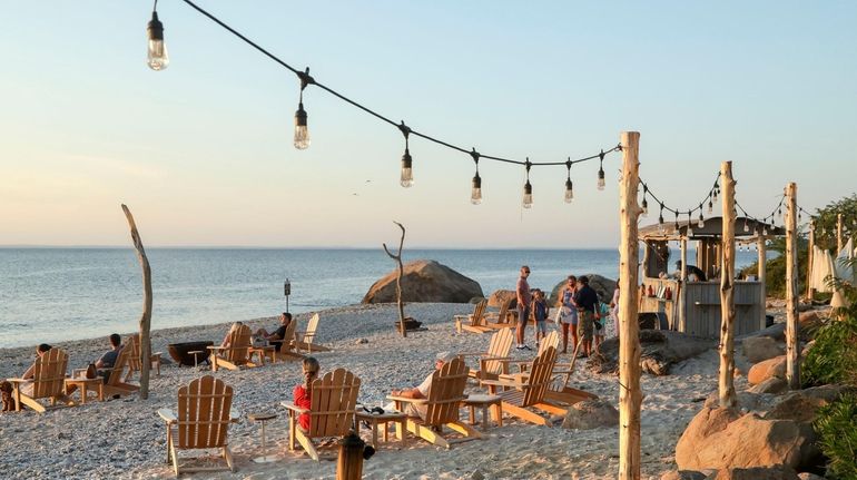 Patrons enjoy drinks from the cabana bar and a beachside...