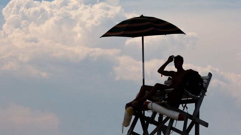 A lifeguard keeps watch over bathers at Jones Beach State...