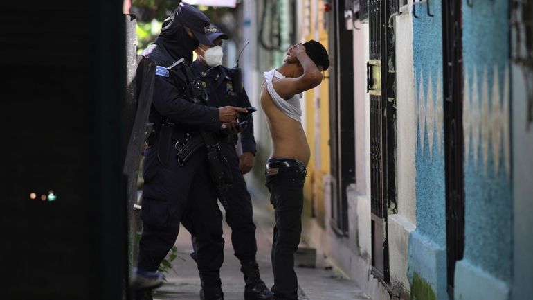 A police officer searches a man in the Kiwanis Community...