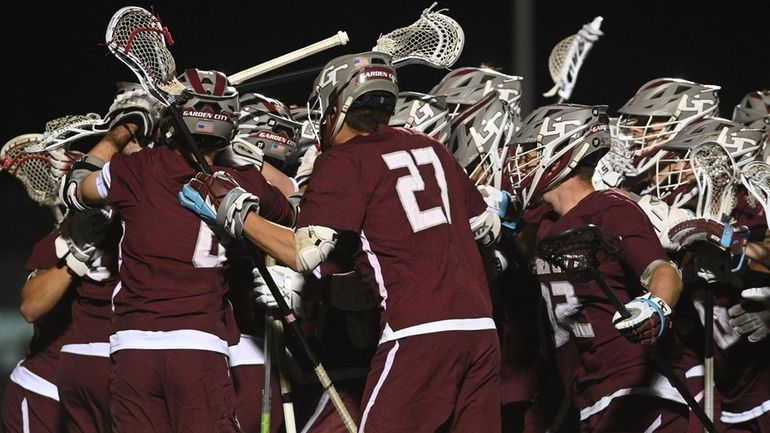 Garden City boys lacrosse teammates celebrate after their 7-2 win...