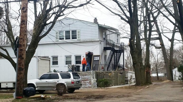 Men perform work on a house on Larkfield Road, East...