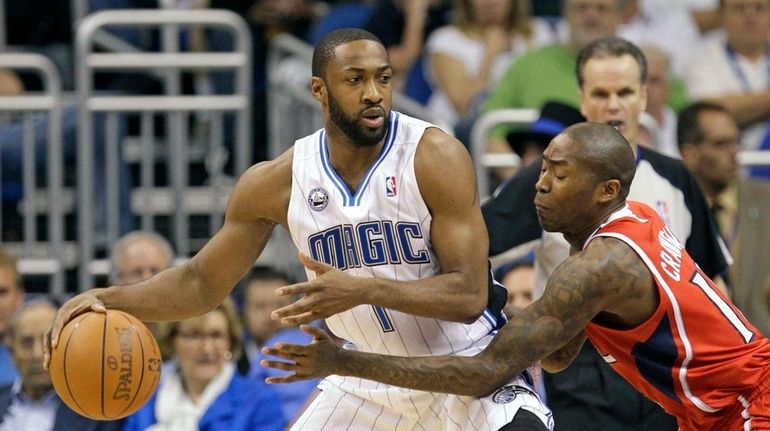 Orlando Magic's Gilbert Arenas, left, looks for a way around...