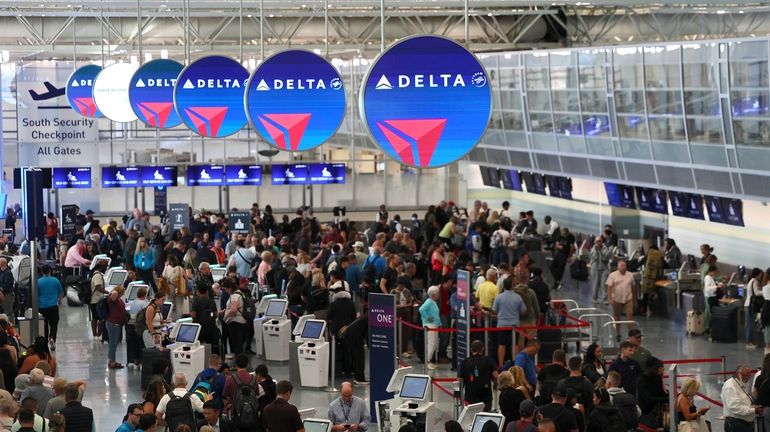 Delayed travelers wait in lines at Minneapolis-St. Paul International Airport...