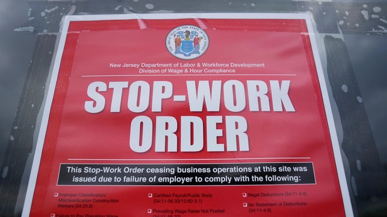 A stop work order is posted on the door of...