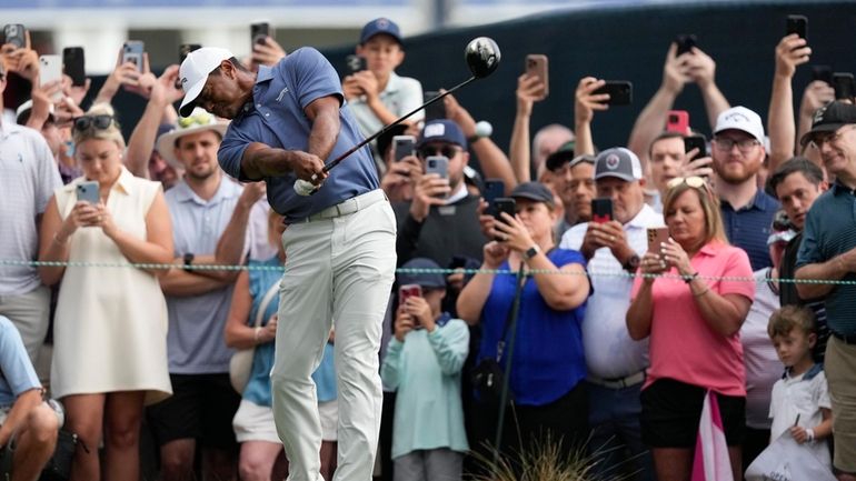 Tiger Woods hits his tee shot on the 13th hole...