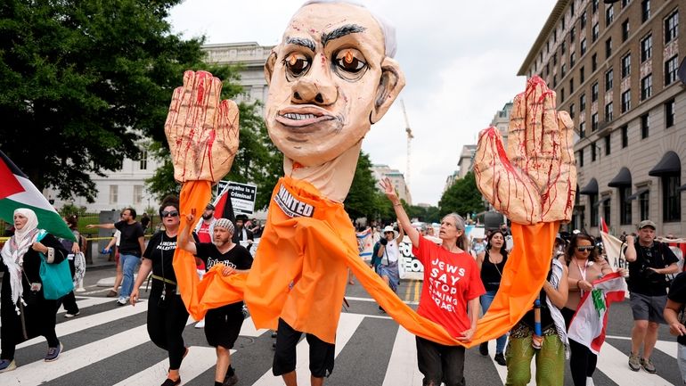 Demonstrators protest the visit of Israeli Prime Minister Benjamin Netanyahu...