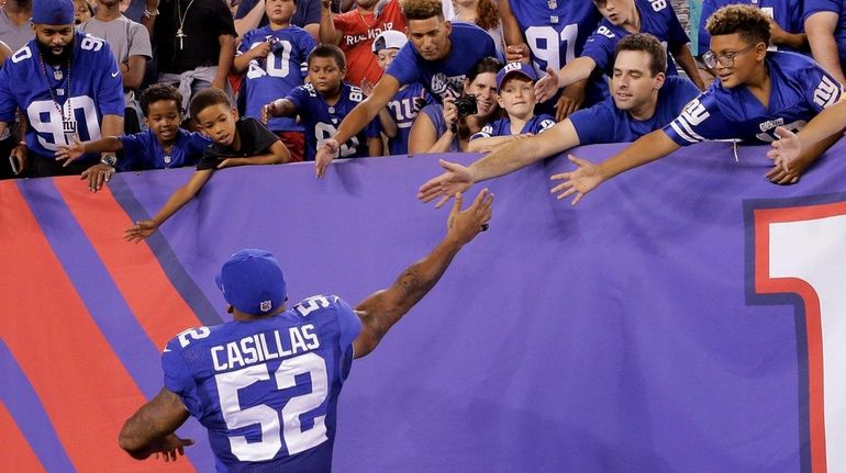 New York Giants outside linebacker Jonathan Casillas (52) greets fans...