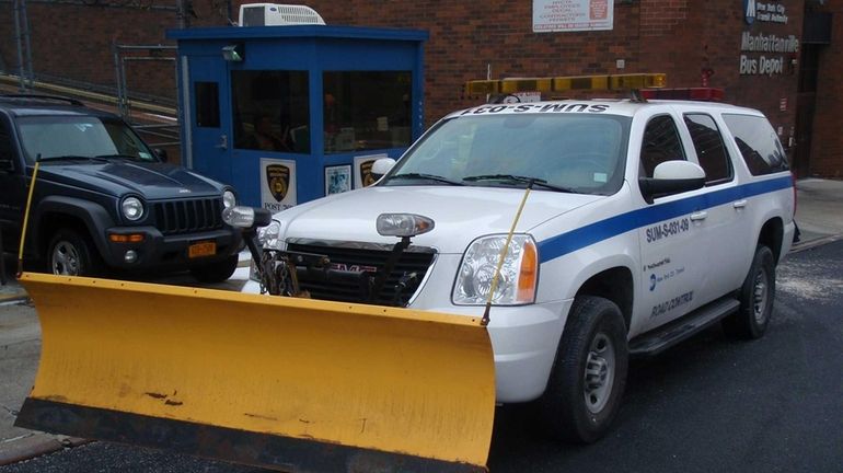 A service truck sits with plow at the ready at...