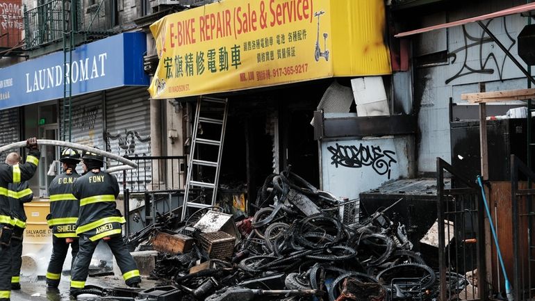 Firefighters work outside a building in Chinatown in Manhattan after...