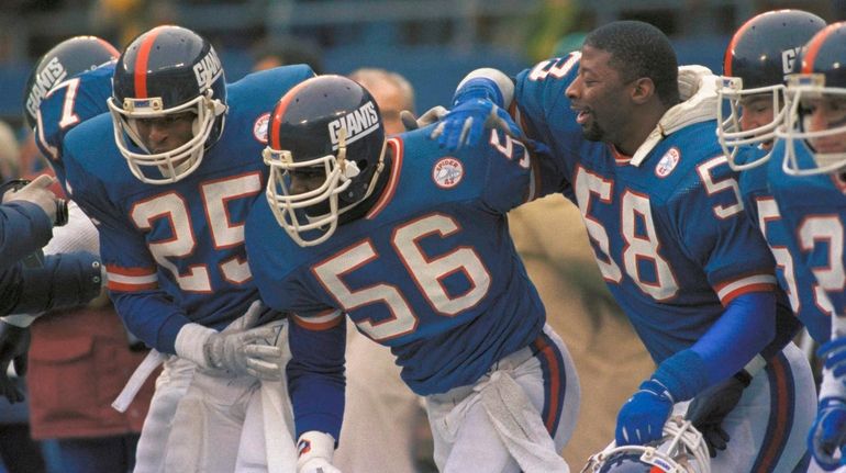 New York Giants linebacker Lawrence Taylor, center, is congratulated by...