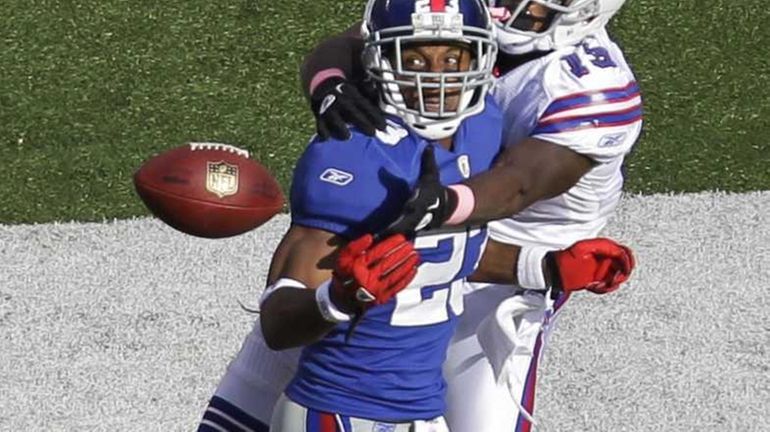 Giants cornerback Corey Webster, front, prepares to intercept a pass...